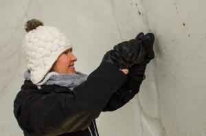Det är mycket jobb med att få igloon riktigt vit på insidan eftersom snön inte är helt ren. Det är en hel del sten och smuts som syns på väggarna. Här är det  Brooke Erdman som rensar bort smutsen. De hål som blir fylls sen med ren snö.